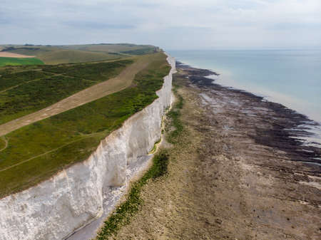 The famous Seven Sisters chalk cliffs by the English Channel. They form part of the South Downs in East Sussex, between the towns of Seaford and Eastbourne in southern England, taken on a bright day.の写真素材