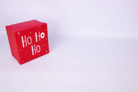 A red Christmas gift box saying Ho Ho Ho on a white background, Christmas gift conceptの写真素材