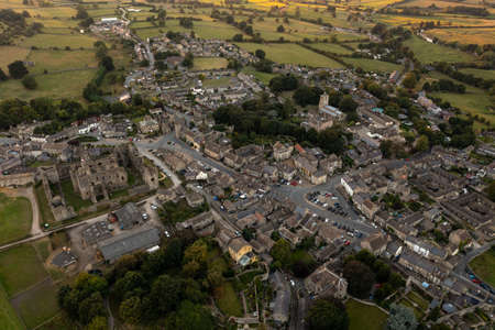 Aerial photo at sunset in the beautiful village of Middleham, Leyburn in North Yorkshire in the UK showing the sun setting over the historical small British village at duskのeditorial素材