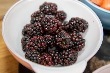 A bowl of delicious red raspberries in a white bowlの写真素材