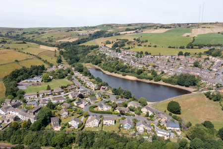 Aerial photo of the historic Yorkshire town of Huddersfield in the UK, showing the residential housing estates by a lake on a sunny day in the summer timeの写真素材