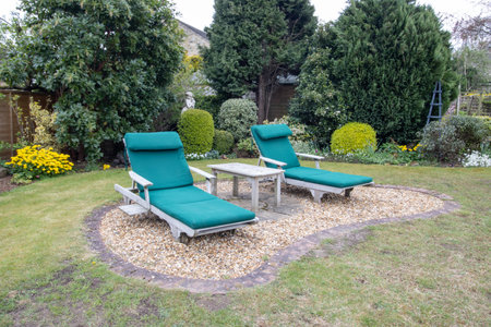 Photo of a typical British garden showing a seating area with sun loungers in the UK gardenの写真素材
