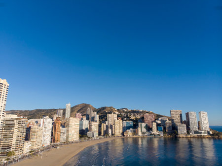 Aerial photo taken in Benidorm in Spain Alicante, showing the beautiful beach of Playa Levante, hotels, buildings, and high rise skyline cityscape with people relaxing on the beautiful beachの写真素材