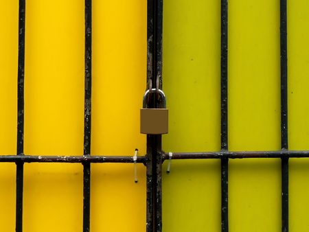 Security lock over yellow wall with metal framesの写真素材
