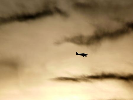 Silhouette a a small plane fly at dusk
