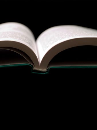Open book with green cover on black with shallow depth of field の写真素材