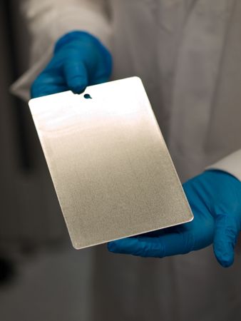 Scientist at work holding a test coating plateの写真素材