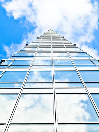 Blue office building with clouds reflectionの写真素材