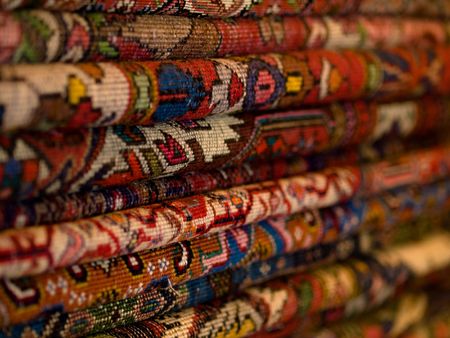 Closeup of a stack of colorful persian carpets with shallow depth of fieldの写真素材