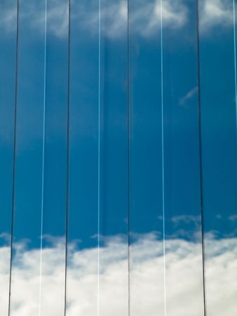 Close up of a glass building with sky reflection