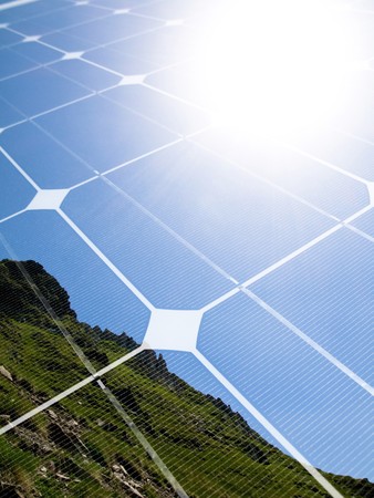 Mountain top with shining sun and photovoltaic panel