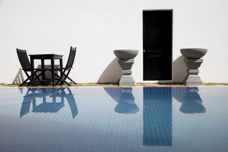 Empty table with chairs  beside a swimming pool in a resortの写真素材