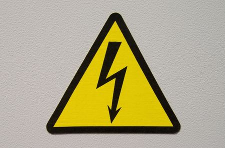 high voltage sign on white metal plate