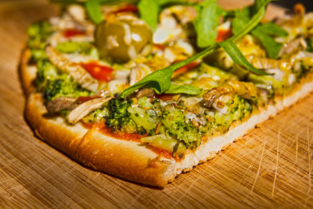 Homemade vegetarian pizza on a wooden platter の写真素材