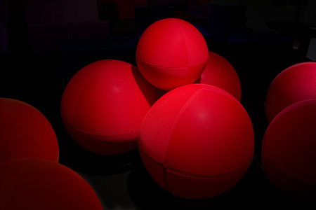 Red balls made of fabric in a dark background.の写真素材