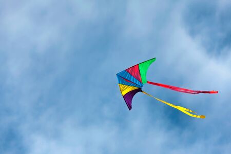 Colorful kite flying on the blue skyの写真素材