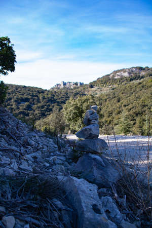 A vertical shot of a stone tower on a hill with trees in the background