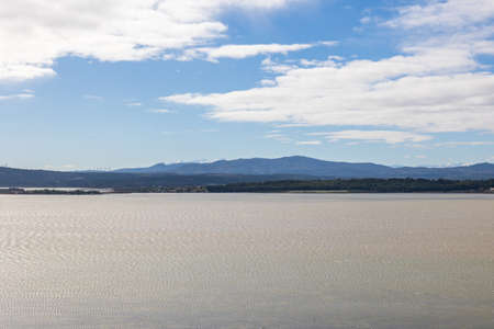 Aerial view of a lake with mountains in the background on a sunny day