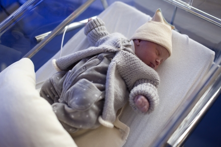 Newborn in baby bed in childbearingの写真素材