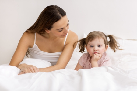 dispute between a child and her mom in white bedroomの写真素材