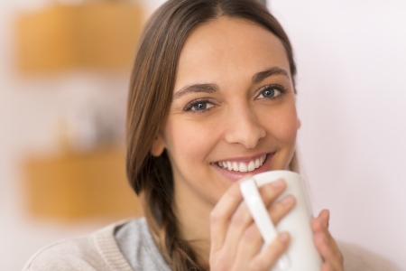 female look at the camera with her cup of teaの写真素材