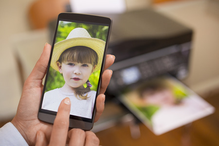 Woman using mobile phone connected to a remote printerの写真素材