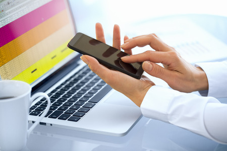 Female business writing sms computer cellphone officeの写真素材