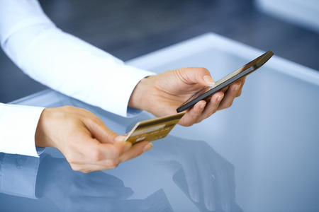 Woman shopping online using mobile phone and credit card .indoor.close-upの写真素材
