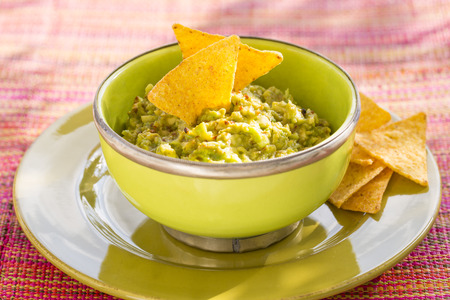 Bowl of Guacamole and nachos, sun lightの写真素材