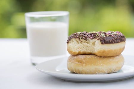 Donuts and Glass of milk in garden for breakfastの写真素材