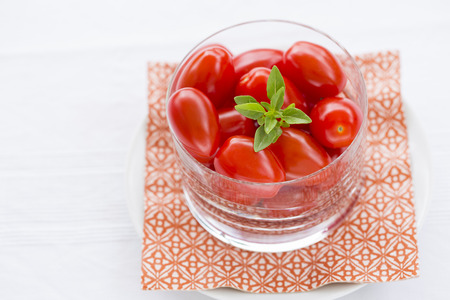 Fresh cherry tomatoes in glass bowlの写真素材