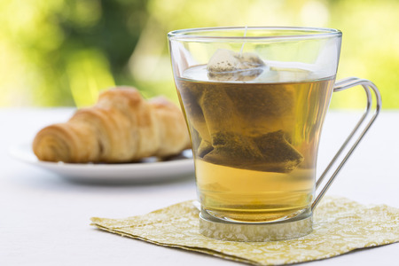 Croissant and hot Tea in gardenの写真素材