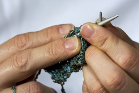 Close up shot of two hands knitting