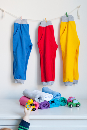 Colorful children's base clothes, the boy reaches for a toyの写真素材