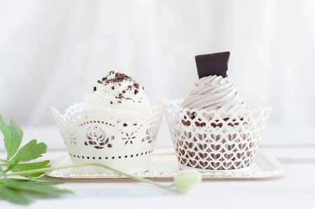 Two wedding cupcakes with white cream and dark chocolate for dessertの写真素材