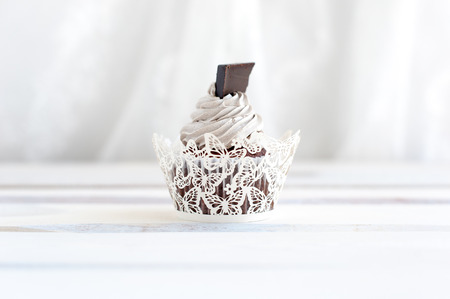 Sweet cream cupcakes with chocolate on the tableの写真素材