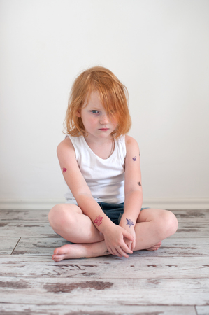 Upset redhead girl in a tattooの写真素材