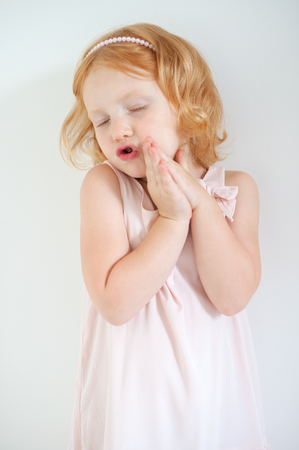 Red-haired girl singing on a white backgroundの写真素材