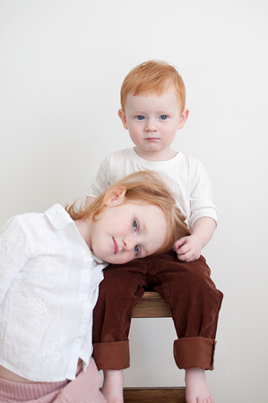 Red-haired brother and sister are cute sitting togetherの写真素材