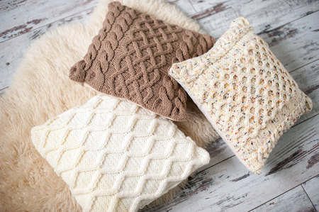 Knitted cushions of natural shades on sheep's clothingの写真素材