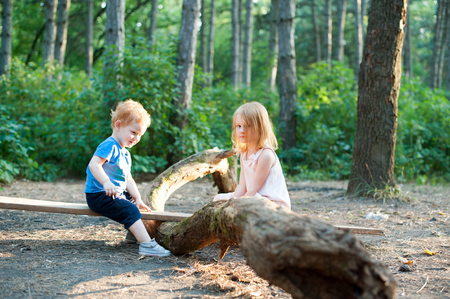 Red-haired brother and sister playing in the woodsの写真素材