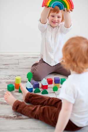 Redheaded children playing with colorful cubesの写真素材
