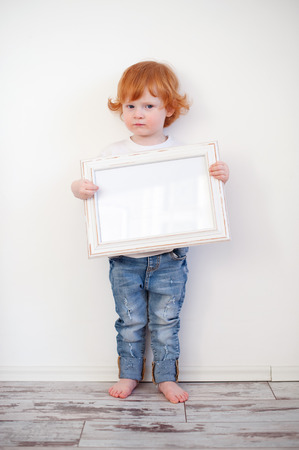 Redhead funny boy with a frame in his handsの写真素材