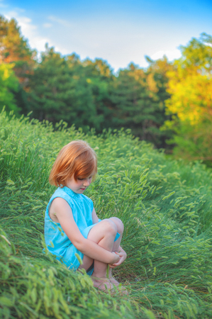The girl is sitting on the edge of the forestの写真素材