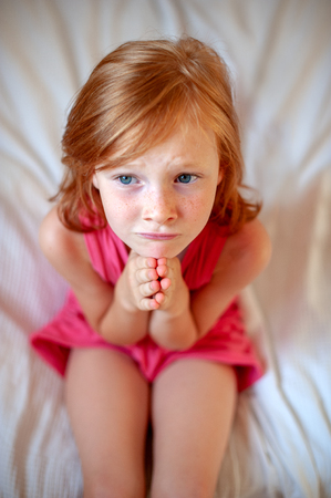 The red-haired girl folded her handsの写真素材