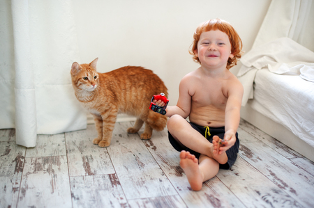 Red-haired boy and red catの写真素材