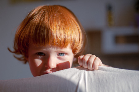 Red-haired child looking at the frameの写真素材