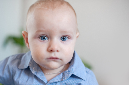 Chubby baby with big blue eyes close-upの写真素材