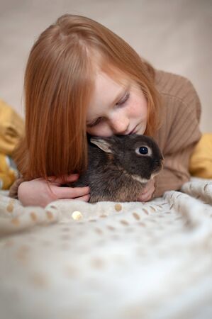 Red-haired girl with a rabbitの写真素材