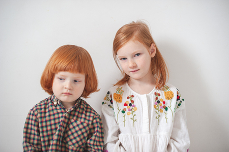 Red-haired children, brother and sister are sitting nearbyの写真素材
